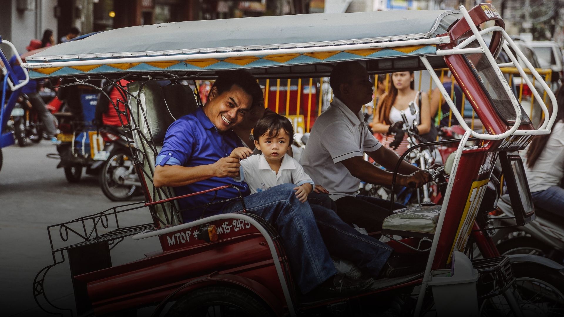 A father and child inside a moving tricycle